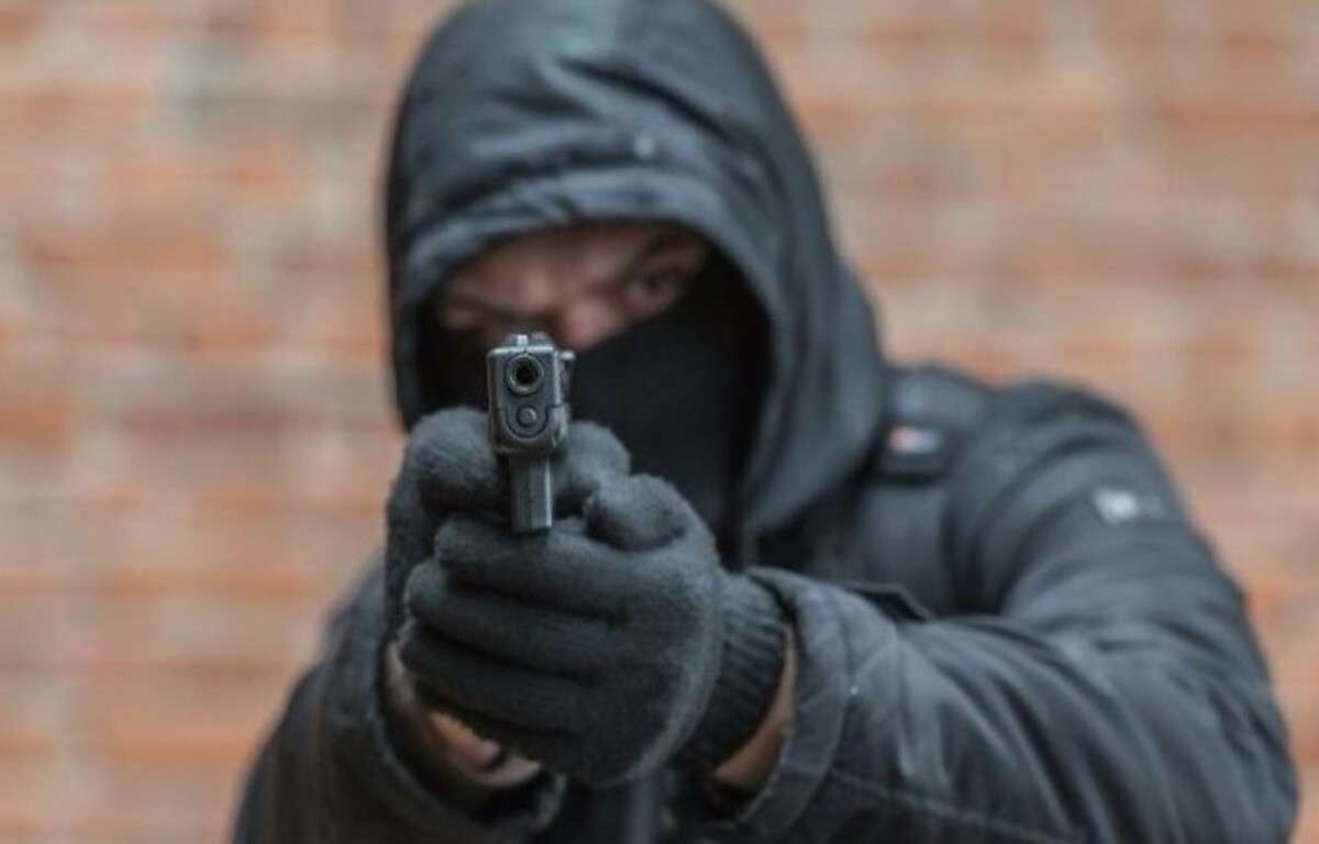 Человек в капюшоне с пистолетом