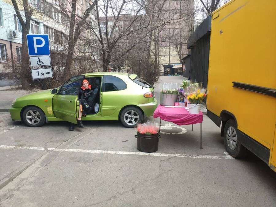 Продает тюльпаны на парковке